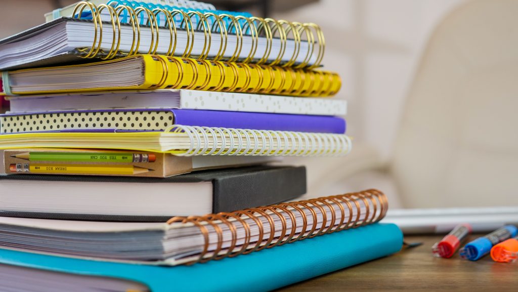 Spiral notebooks | moodiness in teenagers katy, tx | teen counseling | teen therapist | Katy, Texas | Cinco Ranch | Nottingham | Cross Creek Ranch | Cane Island A stack of colorful spiral notebooks sits with pencils and pens nearby. Are teenage mood swings connected to the pressures of school and daily routines? Working with a teen counselor in Katy, TX can help identify what is driving these changes.